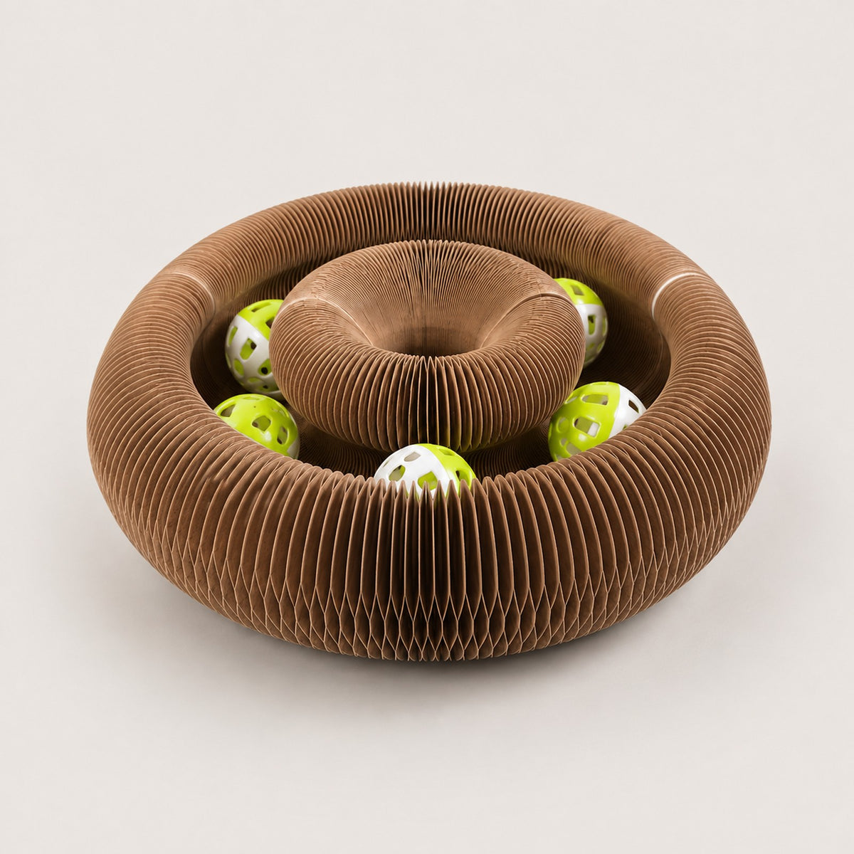 The Pounce Loop folded into its nest form, a ridged bowl with the bell balls inside