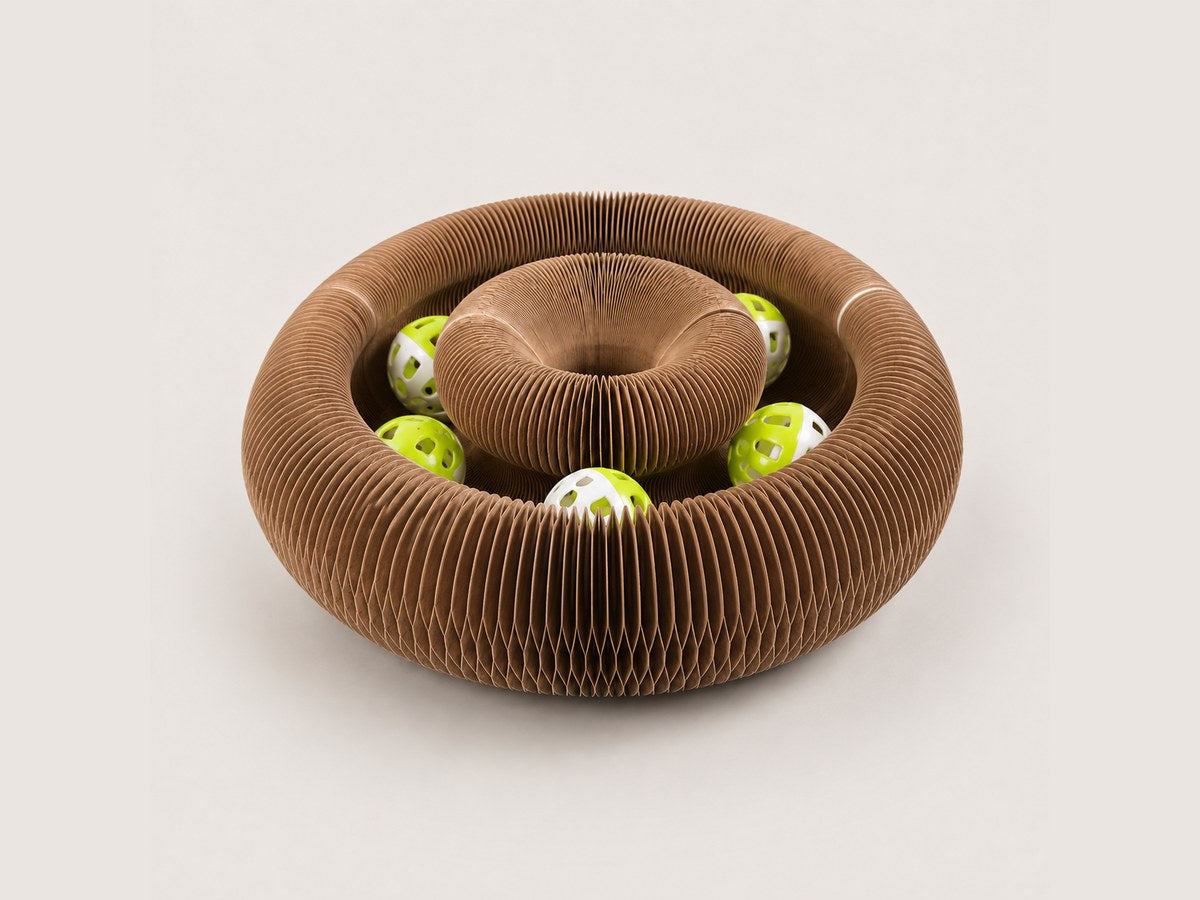 The Pounce Loop folded into its nest form, a ridged bowl with the bell balls inside